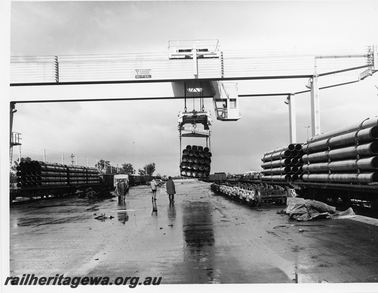 P10664
Vickers Hoskins 25 ton overhead crane, loading pipes to narrow gauge for Mount Tom Price, flat bed wagons, bogies, Kewdale Freight Terminal
