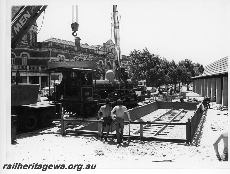 P10836
Placement of R class 174 on display outside Centrepoint No 1 of 3 images, loco (rear and side view), several workers, 