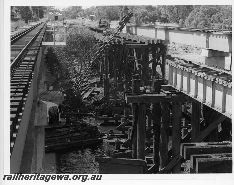 P10845
Construction of new concrete and steel bridge over Swan River, dismantling of old wooden trestle bridge, barge crane, workers, Guildford, ER line, c1966
