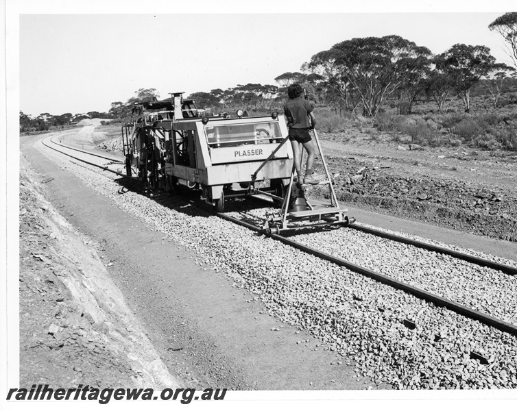 P10851
Plasser track maintenance machine, operator, Kalgoorlie to Kambalda standard gauge line c1972
