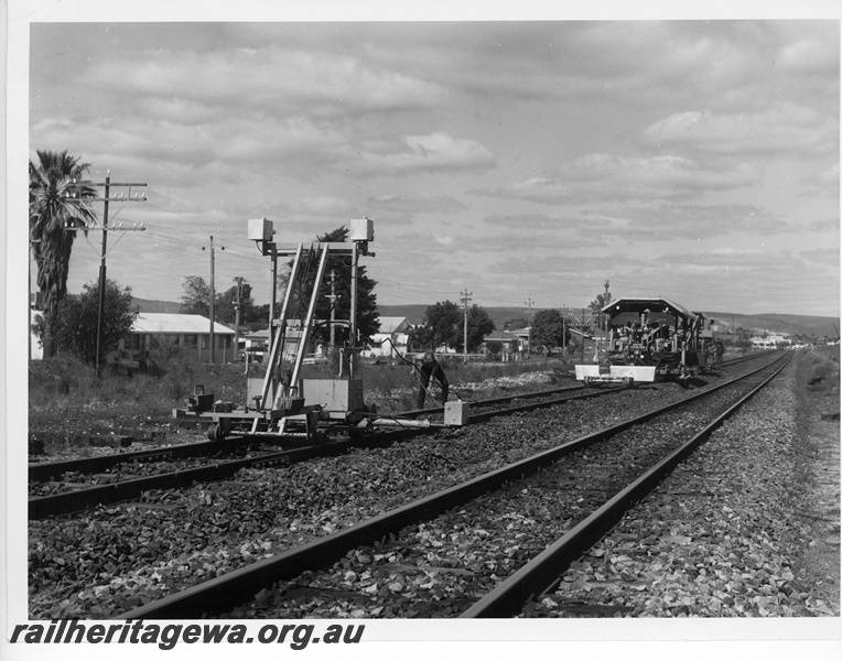 P10853
Track maintenance machines, worker, working on down main line, between Welshpool and Queens Park, SWR line, track level view
