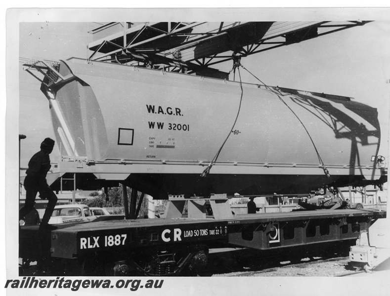 P10928
Standard Gauge WW class 32001 wheat hopper being unloaded from a Commonwealth Railways (CR) RLX class 1887 flat top, at Parkeston, for road transport to West Merredin.
