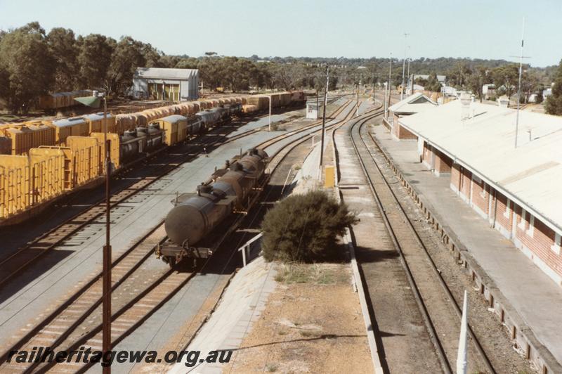 P11058
Station building, yard, lines of wagons, Narrogin, GSR line, elevated view looking south showing tracks on the east side of the yard.
