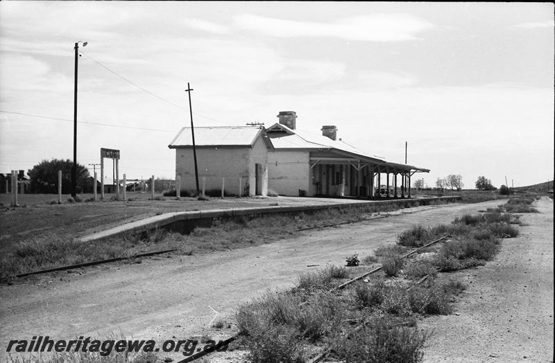 P11144
Station building, Cue, NR line, end and trackside view, track overgrown with weeds.
