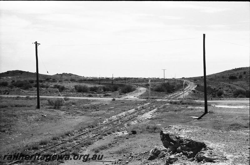 P11148
Level crossing, yard, Cue, NR line, view looking north, abandoned formation of the Big Bell branch on the left.
