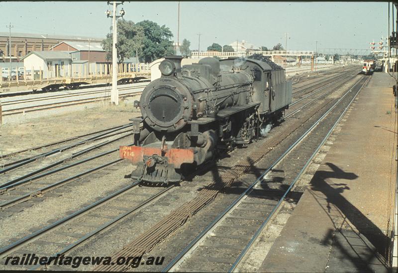 P11272
PM class 714, running through loop, standard gauge flat wagons, railcar in main platform, signals, footbridge to workshops, part of station building and awning in distance, Midland Junction. ER line.
