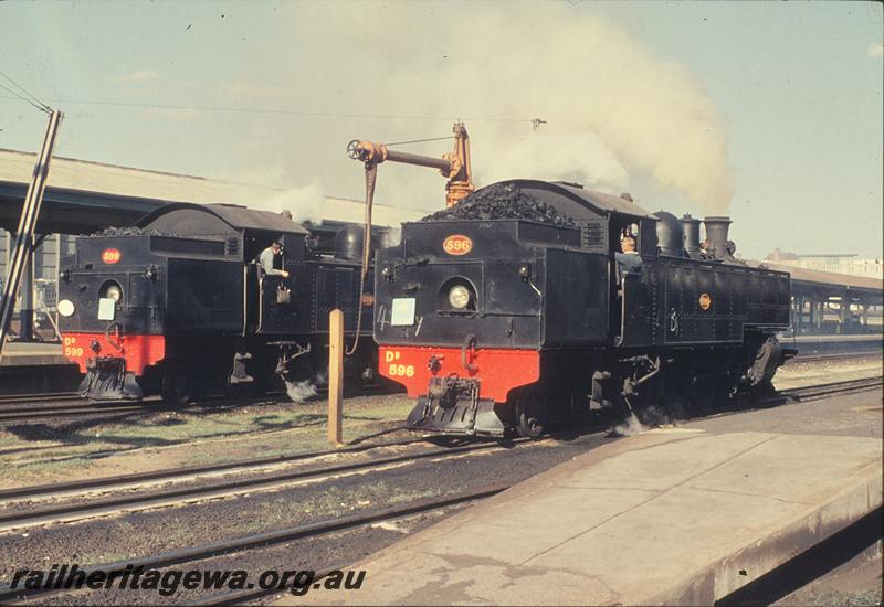 P11716
DD class 599, DD class 596, standby duties, water column, waiting in goods roads, Perth station. ER line.
