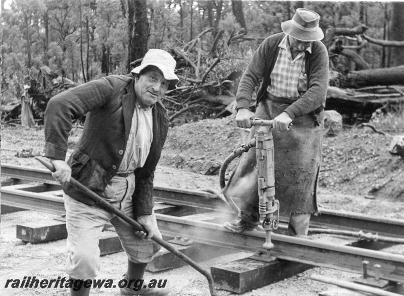 P12026
4 of 12 images of the construction of the Kwinana to Jarrahdale railway. (ref: The Railway Institute Magazine, July 1963), gangers in action demonstrating the driving of dog spikes by means of compressed air.
