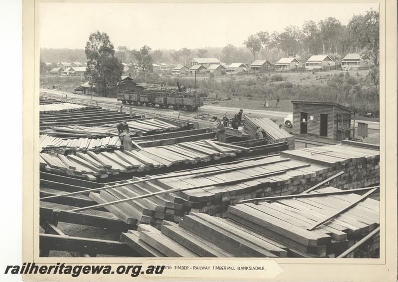 P12051
WAGR timber mill at Banksiadale, workers loading timber into a wagon, loaded wagons in the yard, townsite and worker's houses in the background. (scanned print located in MC1B2G)
