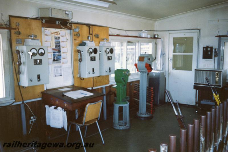 P12091
Signal box, internal view showing a green miniature electric staff instrument  and a red large electric staff instrument, other instruments and levers, Narrogin, GSR line. 

