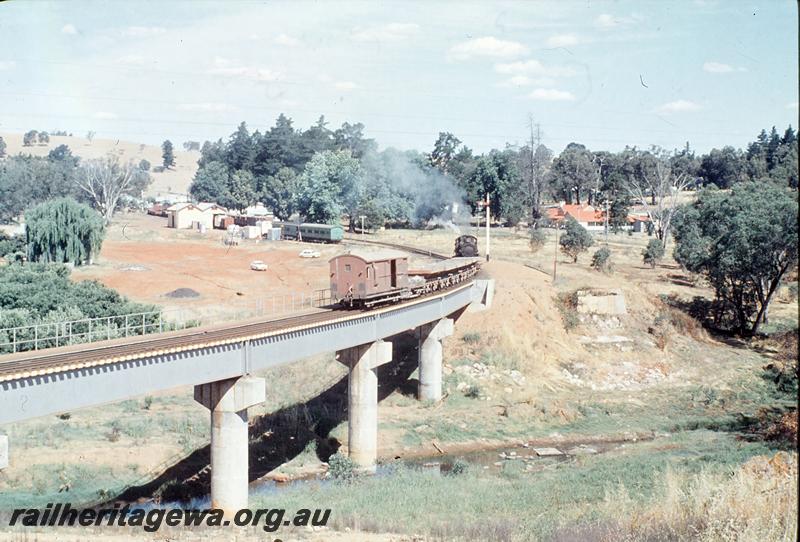 P12413
F class 423, pushing ballast across steel girder bridge, Balingup. PP line. Workman's coach in station, old bridge abutments, goods shed.
