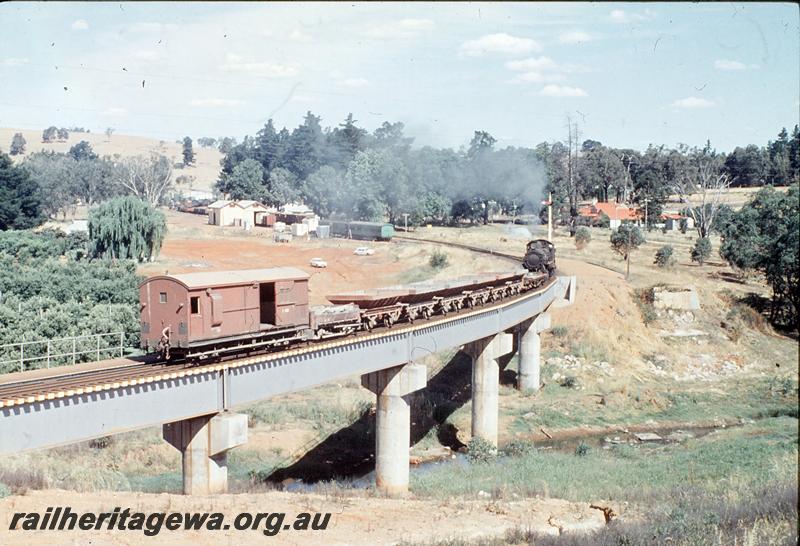 P12414
F class 423, pushing ballast across bridge, Balingup. PP line. Workman's coach in station, old bridge abutments, goods shed.
