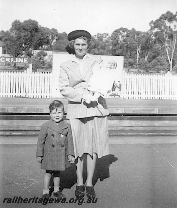 P12613
Platform, nameboard, platform fencing, Clackline, ER line, mother with children.
