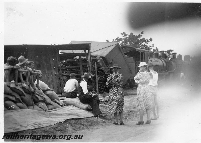 P12643
3 of 4 views of the head on collision of two trains at Gingin, MR line, view shows derailed wagons including a square water tank wagon, interested locals looking on
