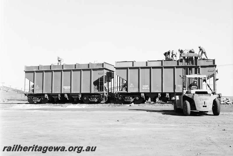 P12682
Hamersley Iron covered hopper wagons HI-1027 and HI1026 being loaded by hand with bagged sodium nitrate
