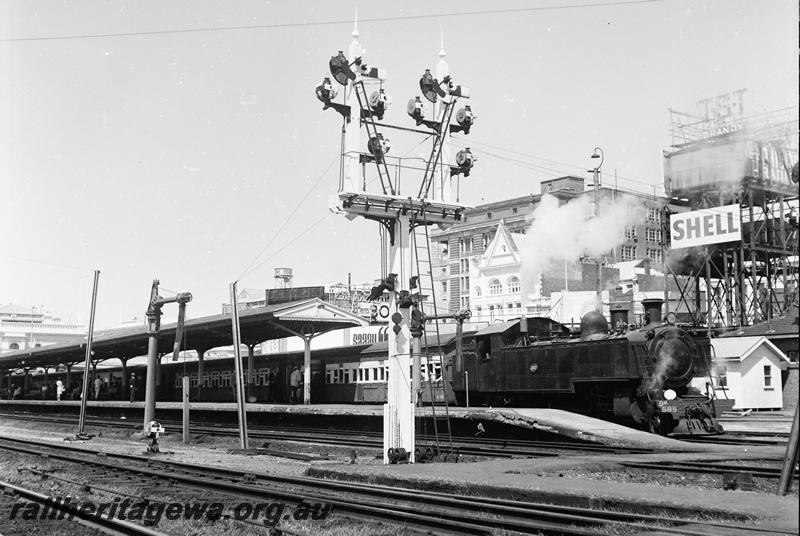 P12732
DM class 585 on suburban passenger train, bracket signal, water tower with advertising hoardings, water column, Perth Station
