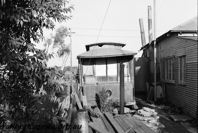 P12775
Tram body, Leonora, abandoned in a back yard, formally from the Leonora to Gwalia tramway, front on view 
