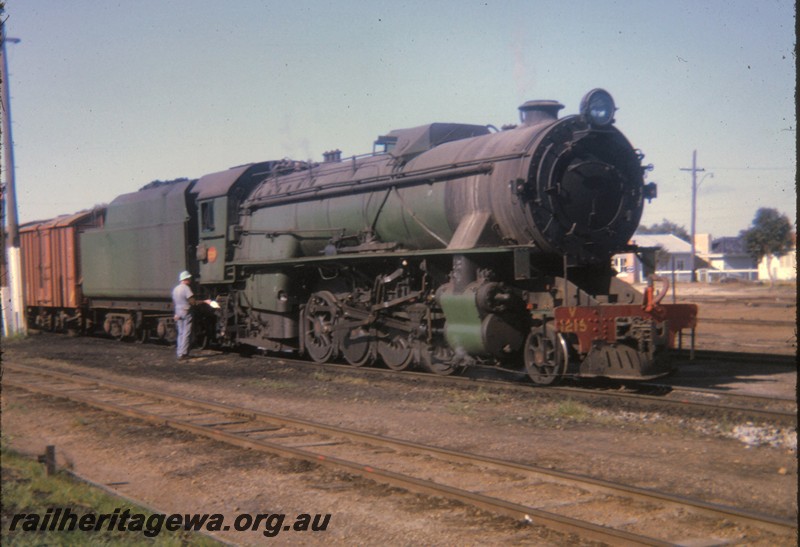 P12830
V class 1215, Tambellup. GSR line, side and front view, crew member at the steps.
