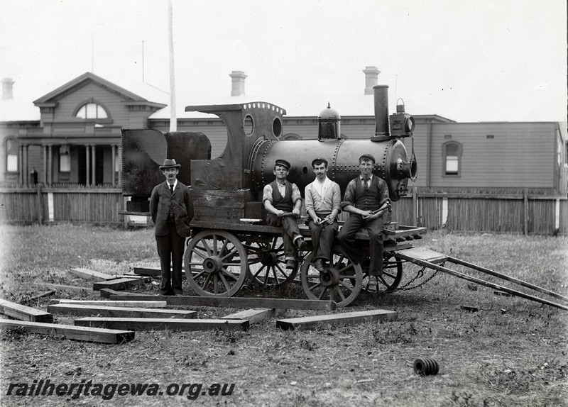 P12910
A mock up of a locomotive on a dray with four workers as a prop in the 