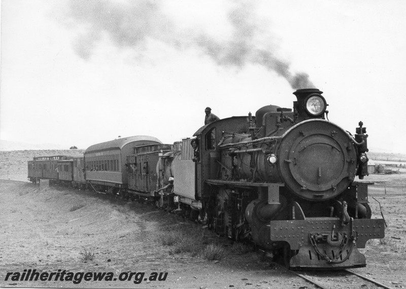 P13099
1 of 3 views of PMR class 720, partially repainted, in the ownership of Steamtown Peterborough in South Australia, in steam hauling a train comprised of brakevans and carriages. (possibly on its trial run) This loco was purchased by Steamtown in 1978 and arrived in Peterborough on 17th, January 1979. (ref: WAGR Steam Locomotives in Preservation, page 27), side and front view
