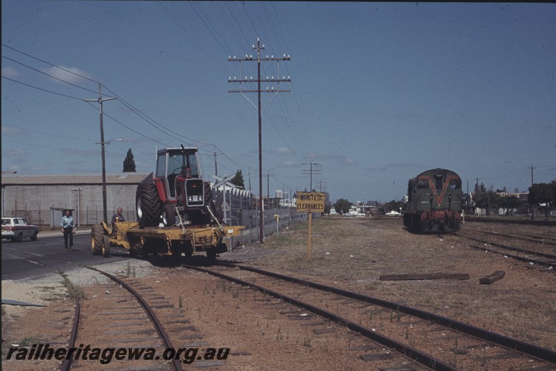 P13191
Tractor moving a four wheel flat wagon with a tractor on board across Whately Crescent from the Massey Ferguson plant in Maylands, F class 42 waiting in the yard to receive the wagons.
