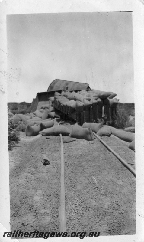 P13504
4 of 5 views of a derailment, date and location Unknown, view shows derailed and smashed wagons with bagged wheat strewn on the ground.
