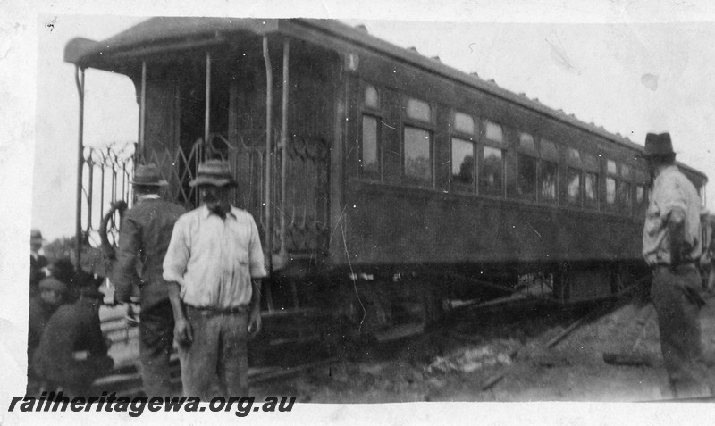 P13525
2 of 4 views of derailment of a platform ended carriage, date and location Unknown, end and side view, workers standing around
