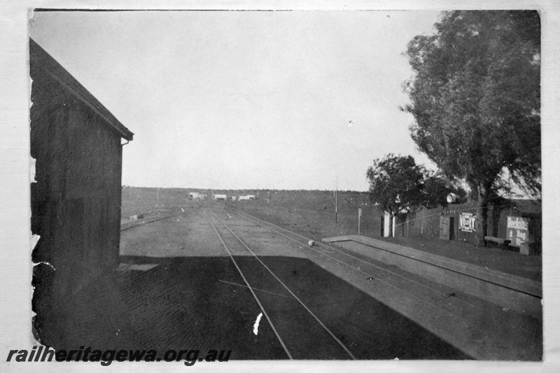 P13559
4 of 6 images of the station buildings and yard at Meekatharra, NR line, view looking south along the line between the goods shed and the platform.
