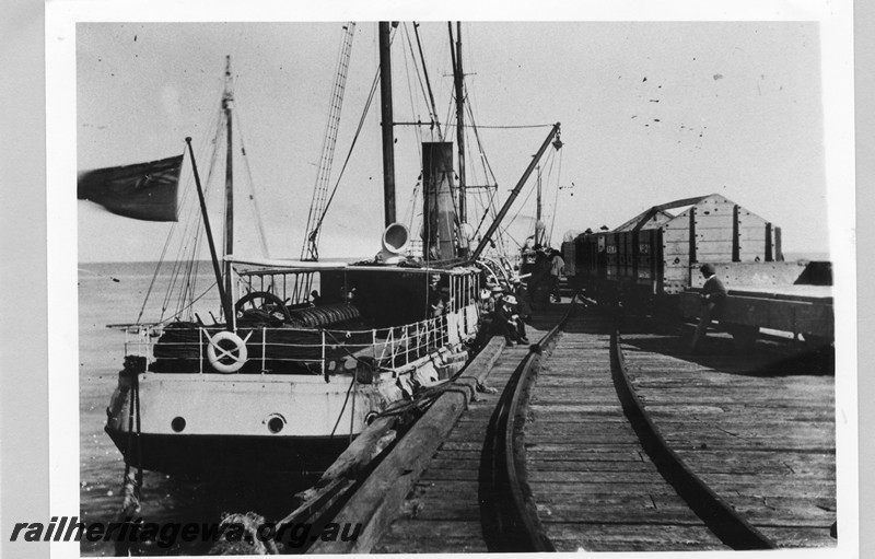 P13599
Coastal streamer tied up at a jetty, gable ended four wheel wagon in rake of wagons, Location Unknown
