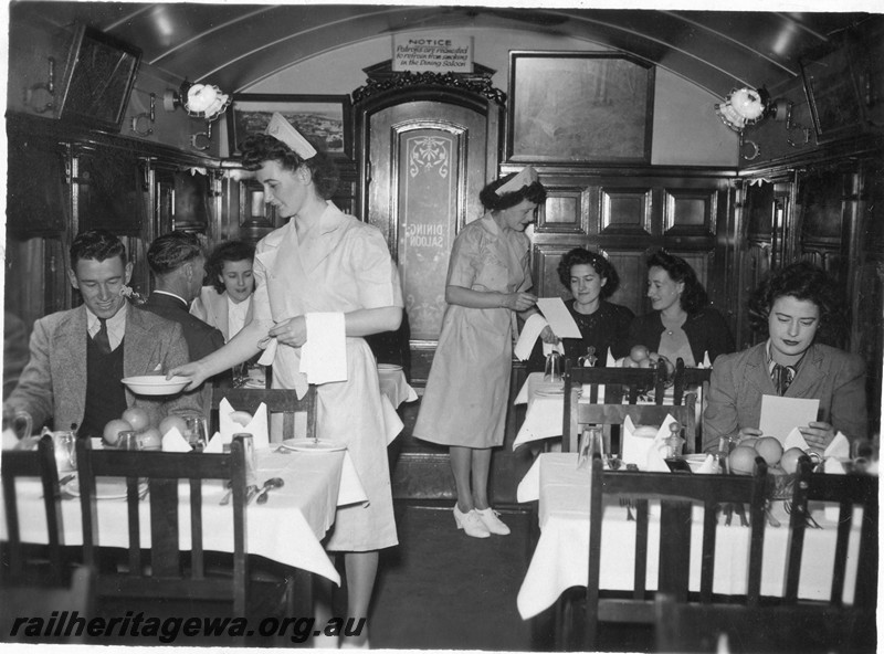 P13672
AV dining car, internal view showing part of the 44 seat eating area, view along the carriage showing passengers being served by waitresses.
