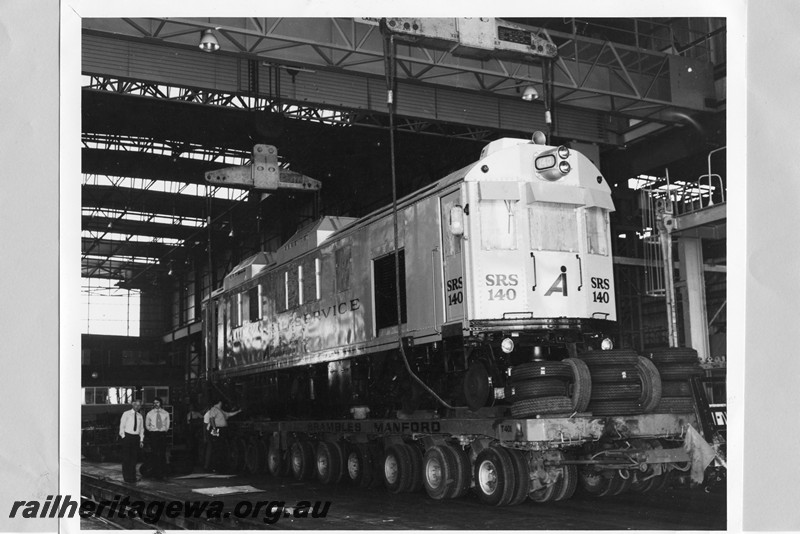 P13738
Speno Rail Service SRS140 being loaded on t a multi wheeled road trailer, side and front view
