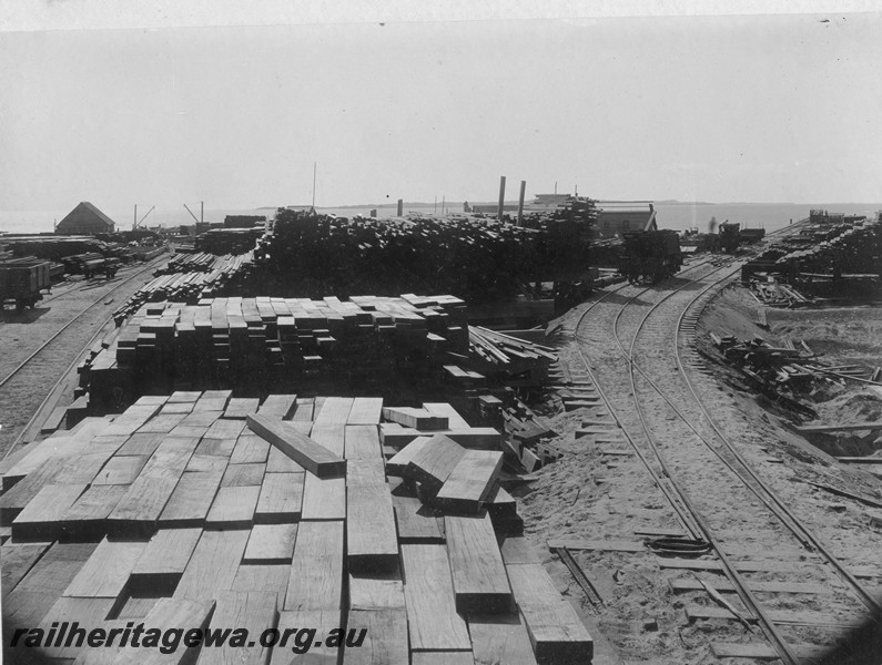 P13764
Stacks of cut timber, jetty with wagons on the tracks, Rockingham, view looking towards the ocean.
