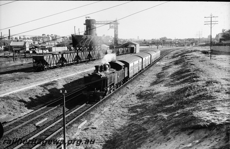 P13972
3 of 17 images of locos, trains and buildings at the East Perth Loco Depot, DD class 598 on a suburban passenger train heading towards Midland passing the coaling tower.
