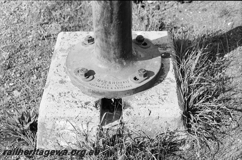 P14011
Base of an upper quadrant signal pole bolted to a concrete base showing the elongated bolt holes, view looking down on the base.
