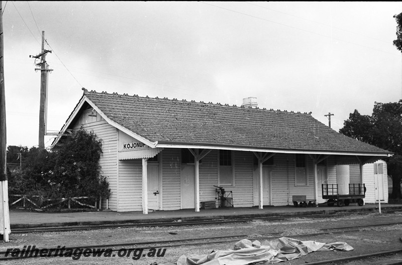 P14017
Station building, nameboard, platform scale, platform trolley, storage shed, Kojonup, DK line, end and trackside view
