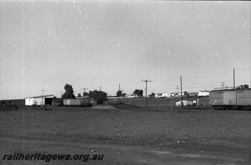 P14021
Station precinct, Meekatharra showing the goods shed, loading platform, X class loco and wagons in the yard, overall view of the precinct
