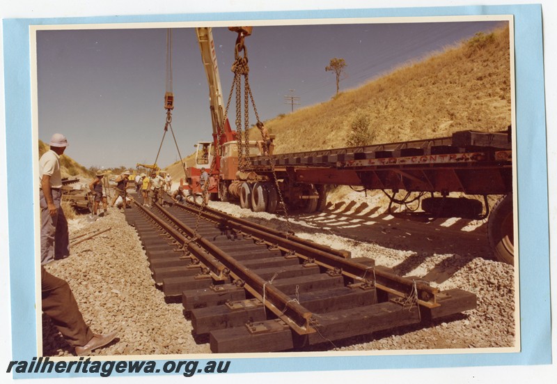 P14105
2 of 3 Trackwork within a cutting using a Bell Bros. crane to lift panels of track into position.
