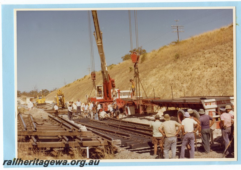 P14106
3 of 3 Trackwork within a cutting using a Bell Bros. crane to lift panels of track into position.
