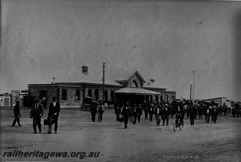 P14118
Station building, Coolgardie, EGR line, streetside view with a crowd of people leaving the station
