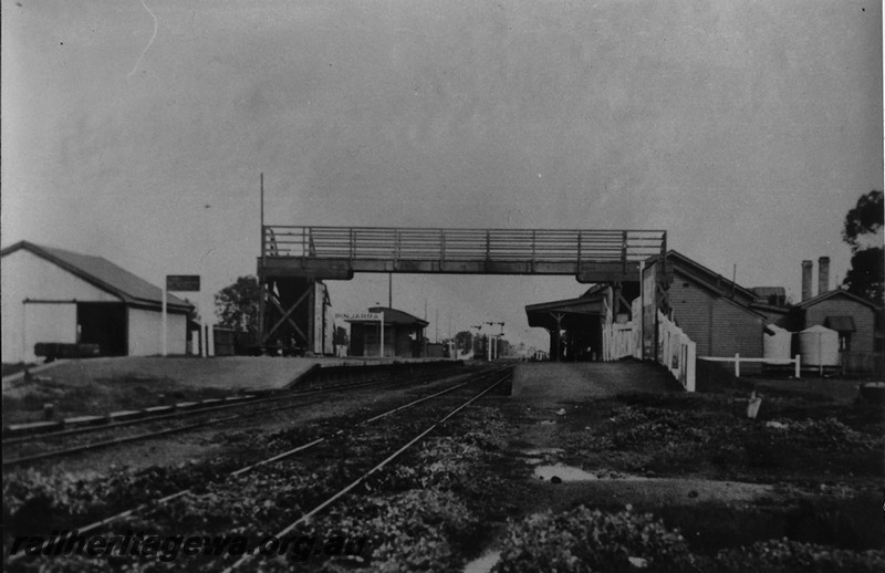 P14128
Station building, footbridge, goods shed, Pinjarra, SWR line, view looking down the line 
