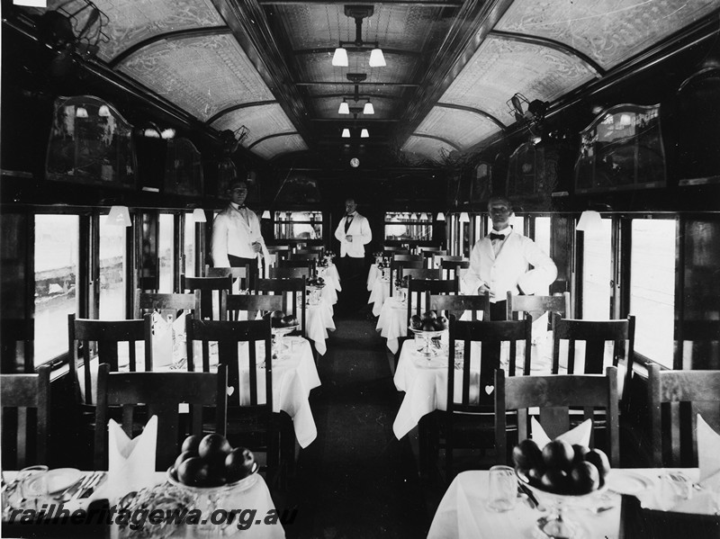 P14141
Commonwealth Railways (CR) dining carriage, internal view with waiters in position.
