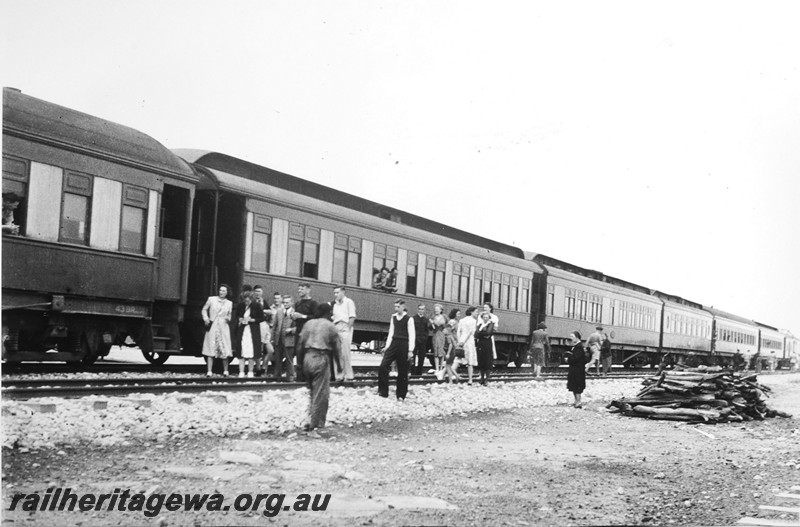 P14146
Commonwealth Railways (CR) passenger train, stopped at a Unknown location on the TAR line, passengers stretching their legs, c1940
