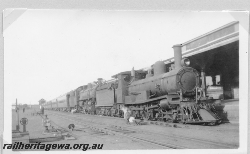 P14180
R class with an oil headlight and a bar cowcatcher coupled to a P class hauling a passenger train, Kalgoorlie station, ERG line, view along the train.
