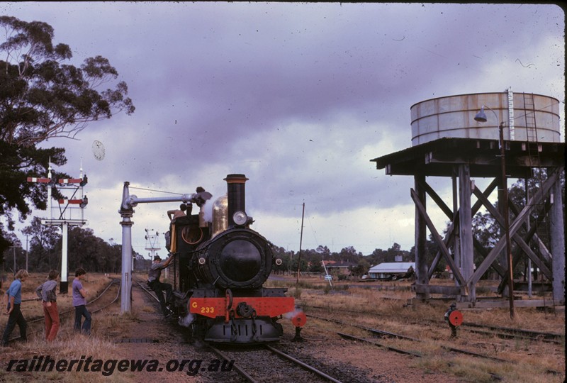 P14350
Water tower, 10,000 gallon squatters tank, water column, G class 233 Leschenault Lady taking on water, front view, semaphore signals, Boyanup, BB line.
