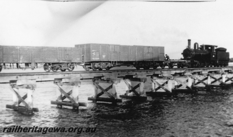 P14452
G class 4-6-0, NS class shunters float, Jetty, Busselton, loco hauling bogie open wagons back to shore
