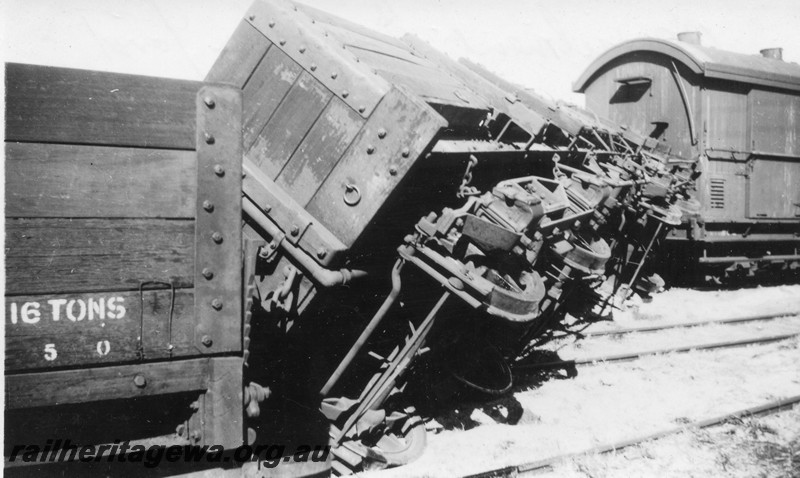P14489
1 of 3 images of a derailment of a R class open bogie wagon in Busselton yard, BB line, view shows the wagon tilted on its side showing the underframe, c1960s
