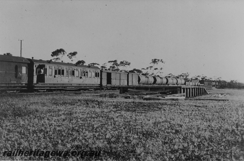 P14508
AP class carriage next to the brakevan on mixed train, bogie tank wagons including JD class wagons, loading platform, Bromus siding, CE line, view along the train 
