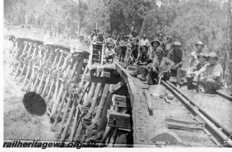 P14511
Trestle bridge over the Matilda River, BN line, workers sitting on the bridge, view along the bridge.
