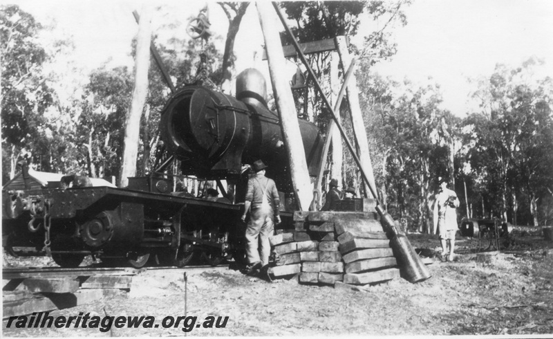 P14523
M class loco boiler being lifted onto or off its chassis, outdoor work area, timber derricks
