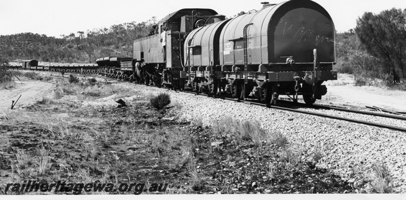 P14643
UT class 664 hauling a ballast train bunker first, two JA class tank wagons, attached to the bunker end of the loco, Cairn Hill, MR line, view along the train.
